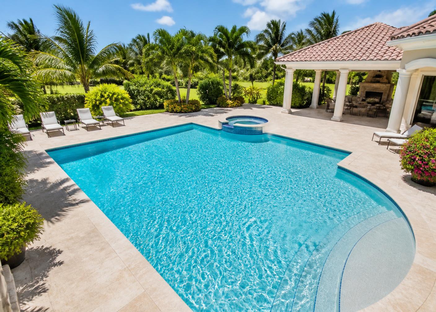 Luxury backyard pool with spa and palm trees on a sunny day